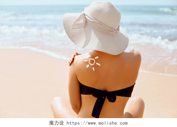沙滩上穿着泳衣的美女肩上涂抹了防晒霜